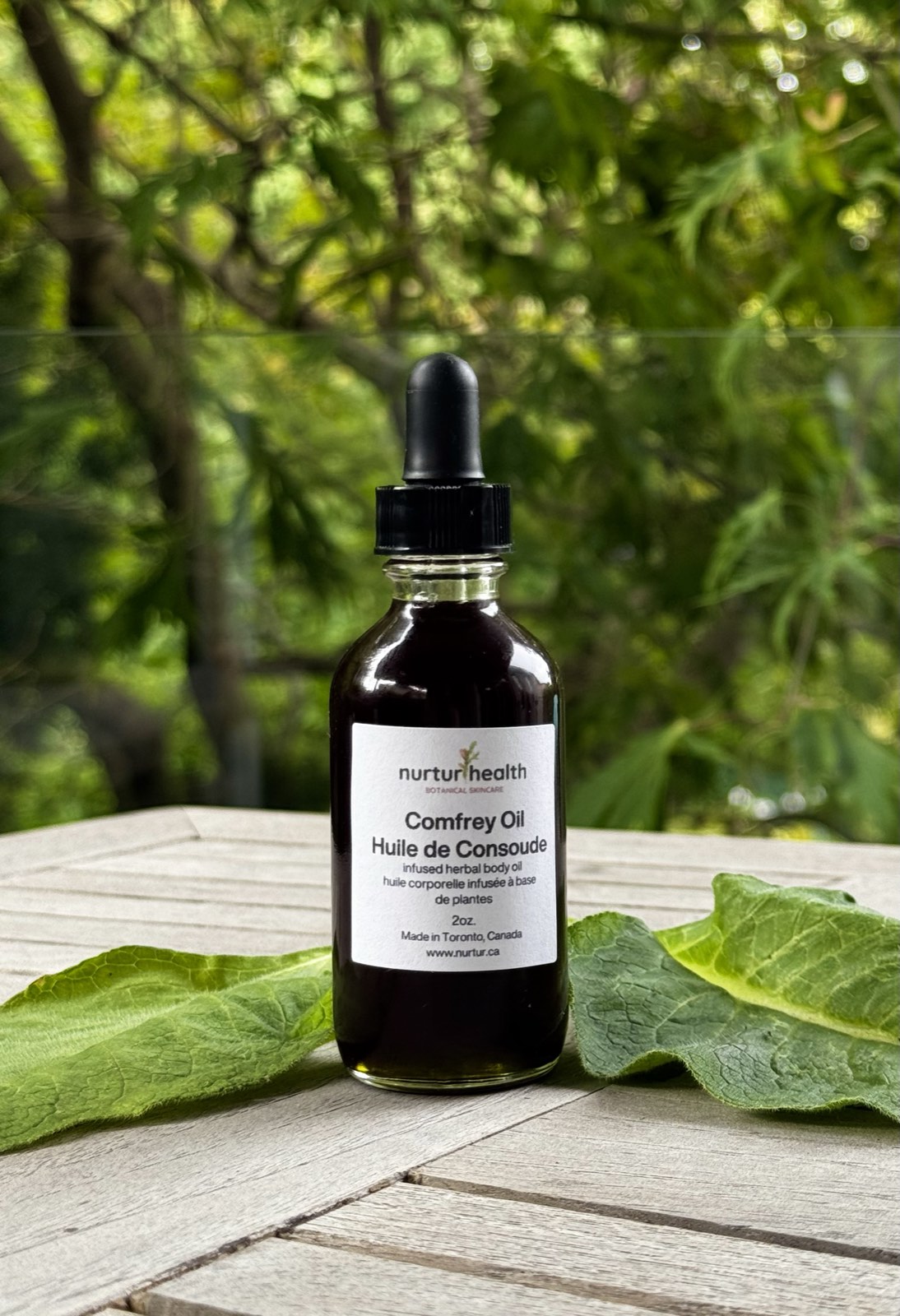 Amber bottle of dark green comfrey infused oil