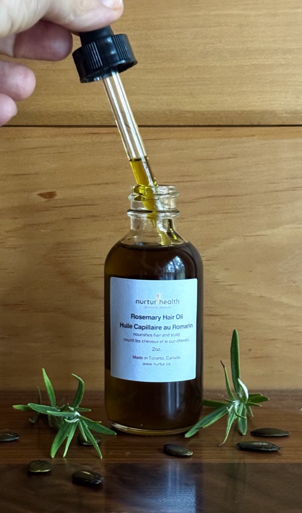 The glass dropper lifted from the Rosemary Hair Oil bottle